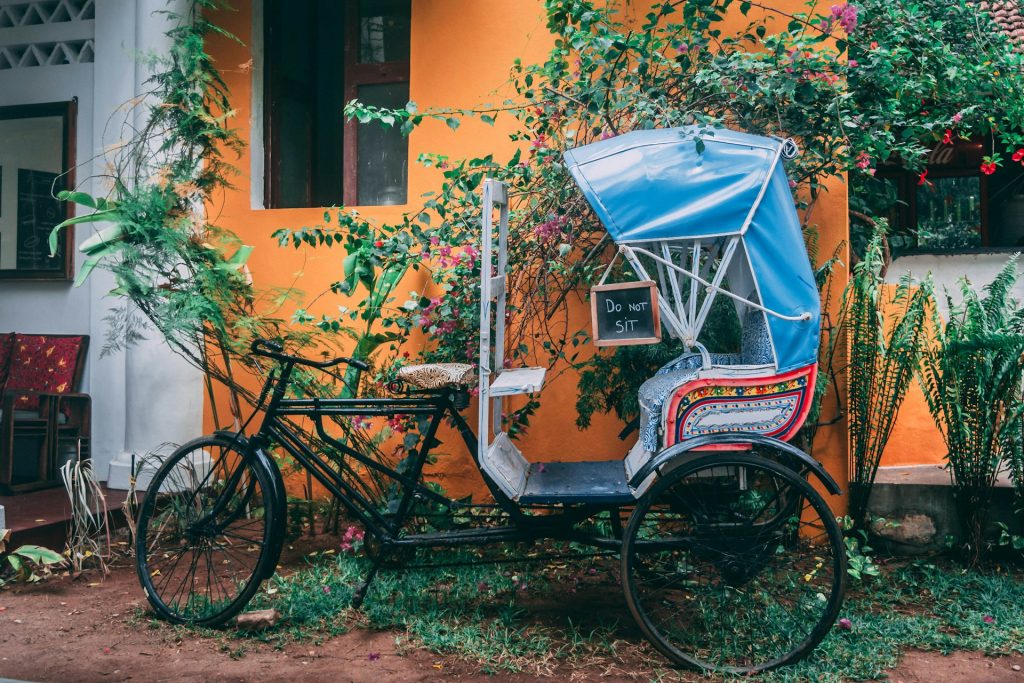 Risciò colorato posteggiato davanti a una casa