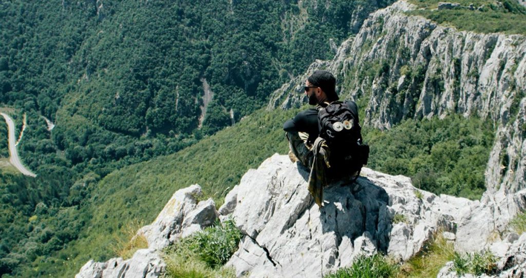 hiking, ragazzo seduto su una roccia in montagna