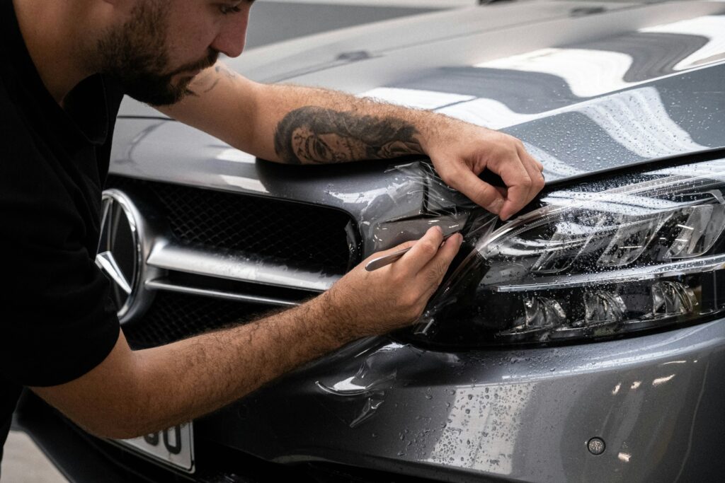 Uomo che esegue car wrapping su auto