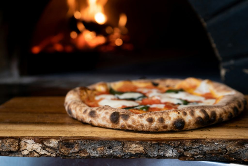 Pizza con forno per pizza sullo sfondo