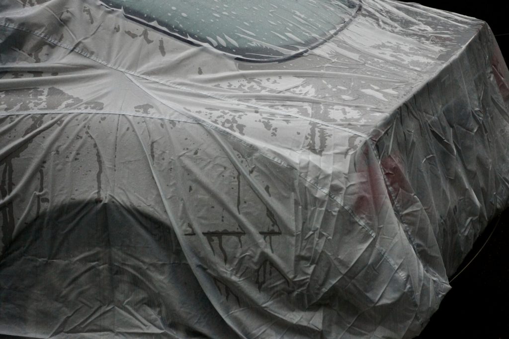 auto sotto un telo protettivo per l'inverno