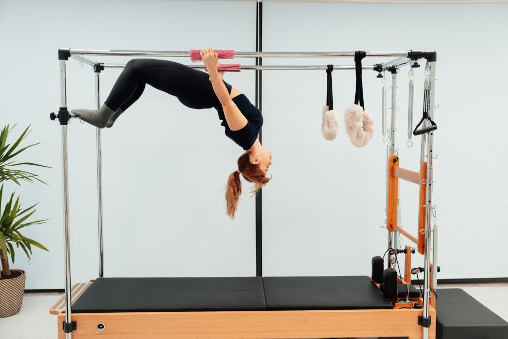 Ragazza che si allena sul Reformer per Pilates