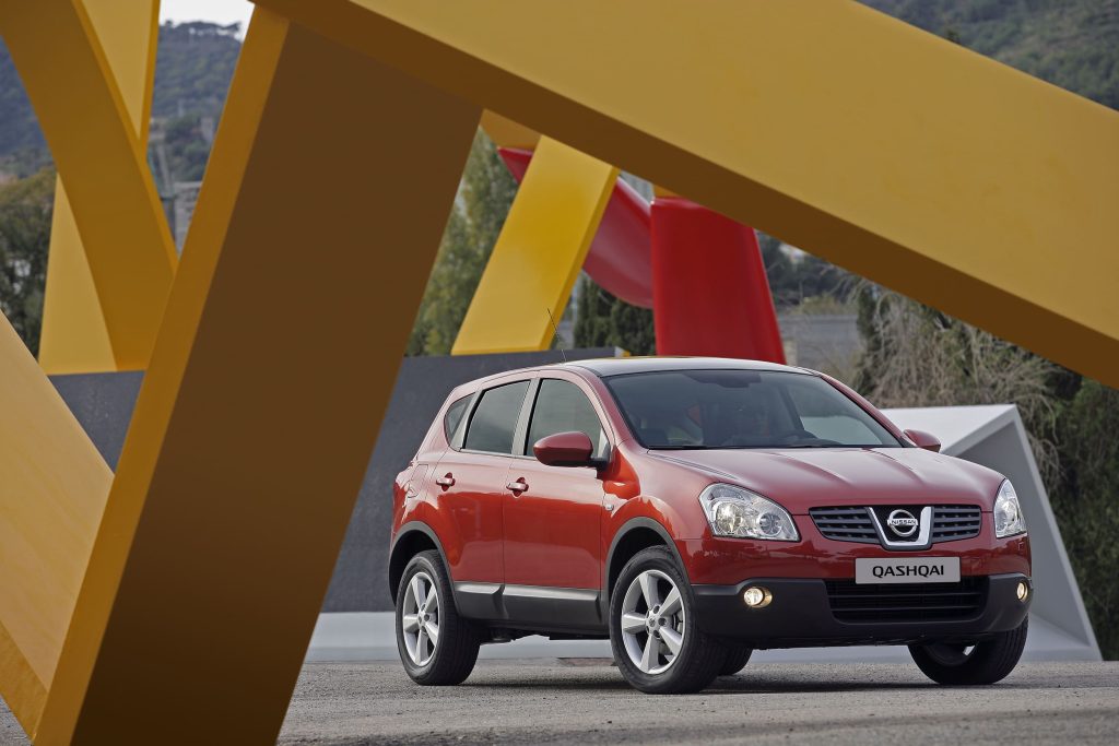 Nissan Qashqai arancione rossa ferma in uno spazio artistico