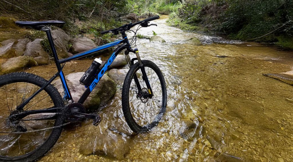 MTB blu che guada un fiume