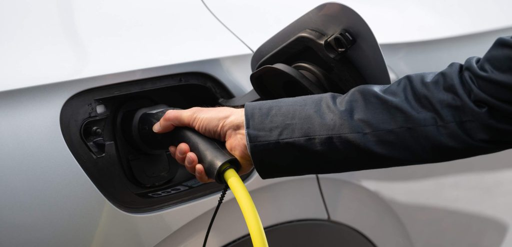 Mano che rifornisce auto elettrica