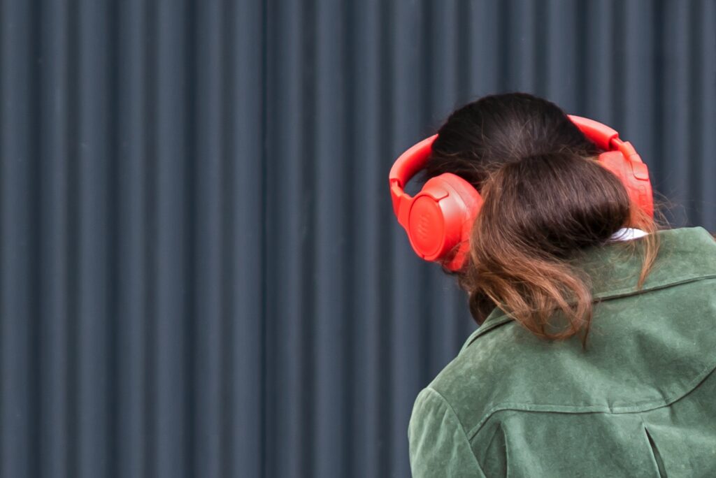 ragazza di spalle con cuffie over-ear rosa