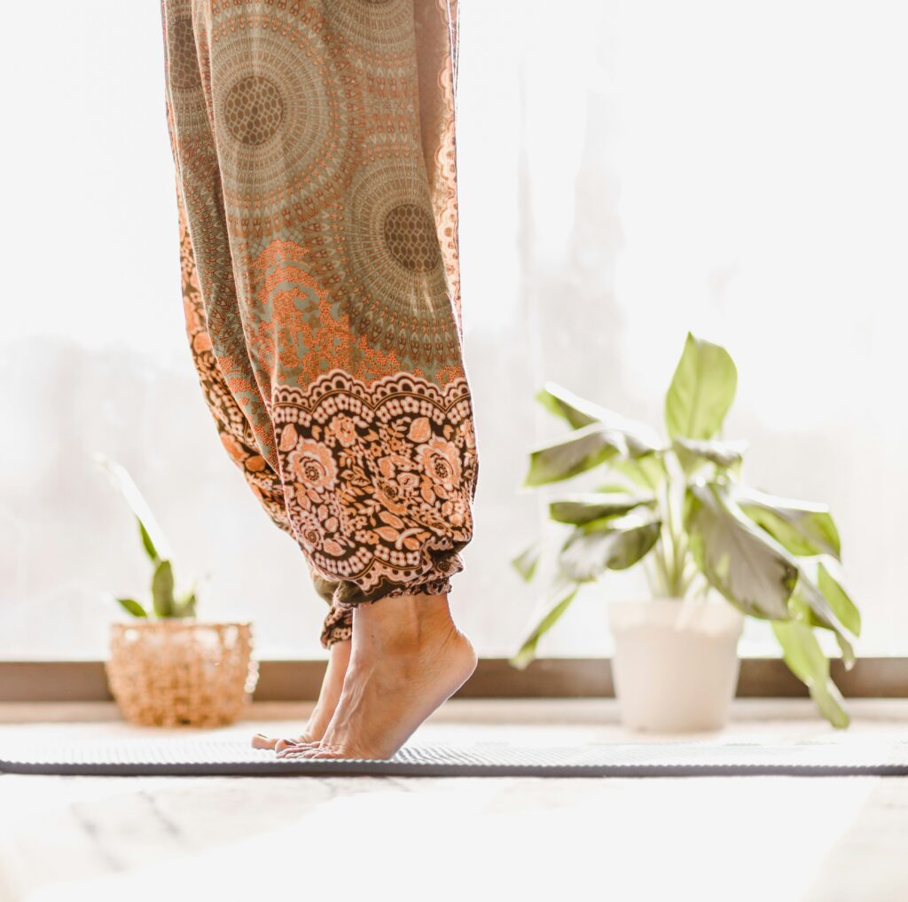gambe di persona che fa yoga con piantine