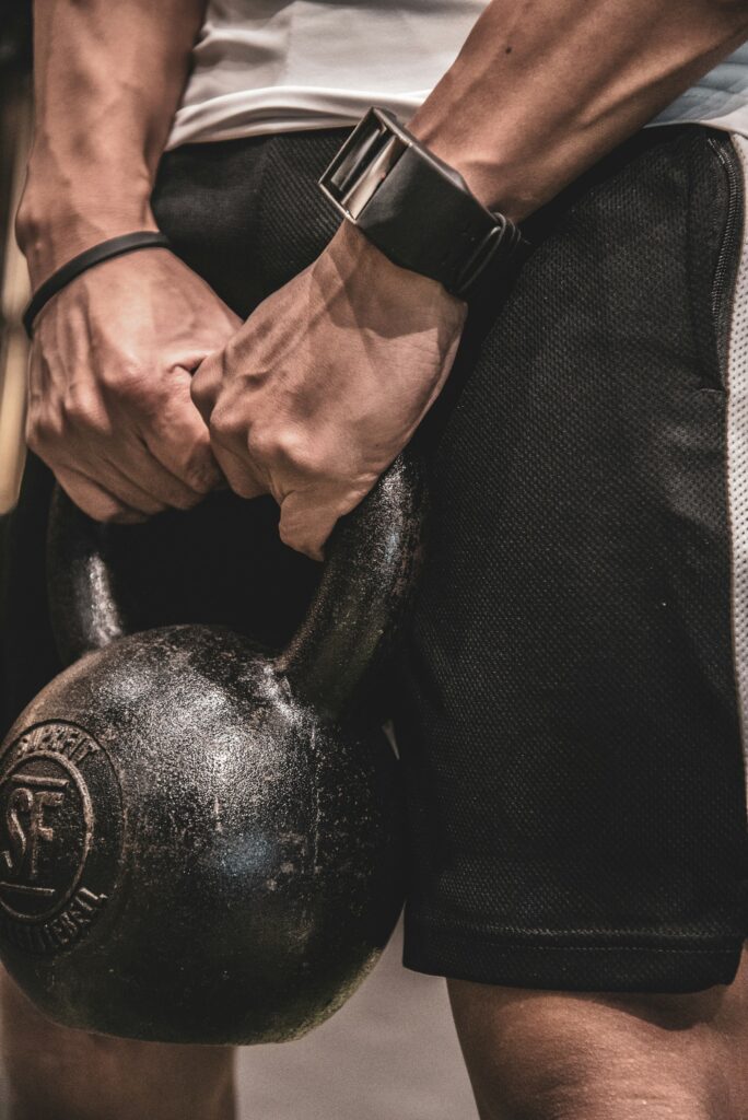 dettaglio uomo che solleva kettleball