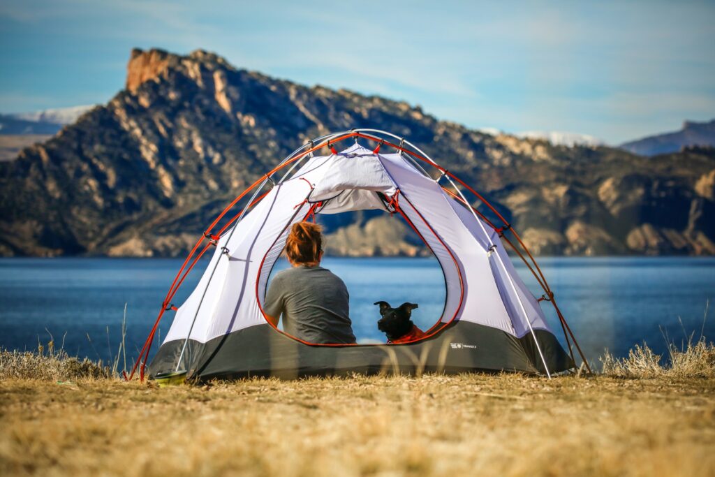 Tenda sulle rive del lago con donne e cane all'interno